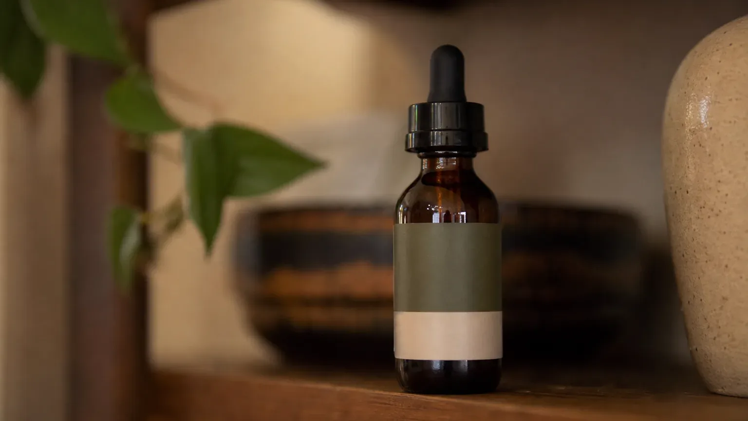A single tincture bottle with a dual-tone label indicating combined CBD and THC content on a wooden shelf