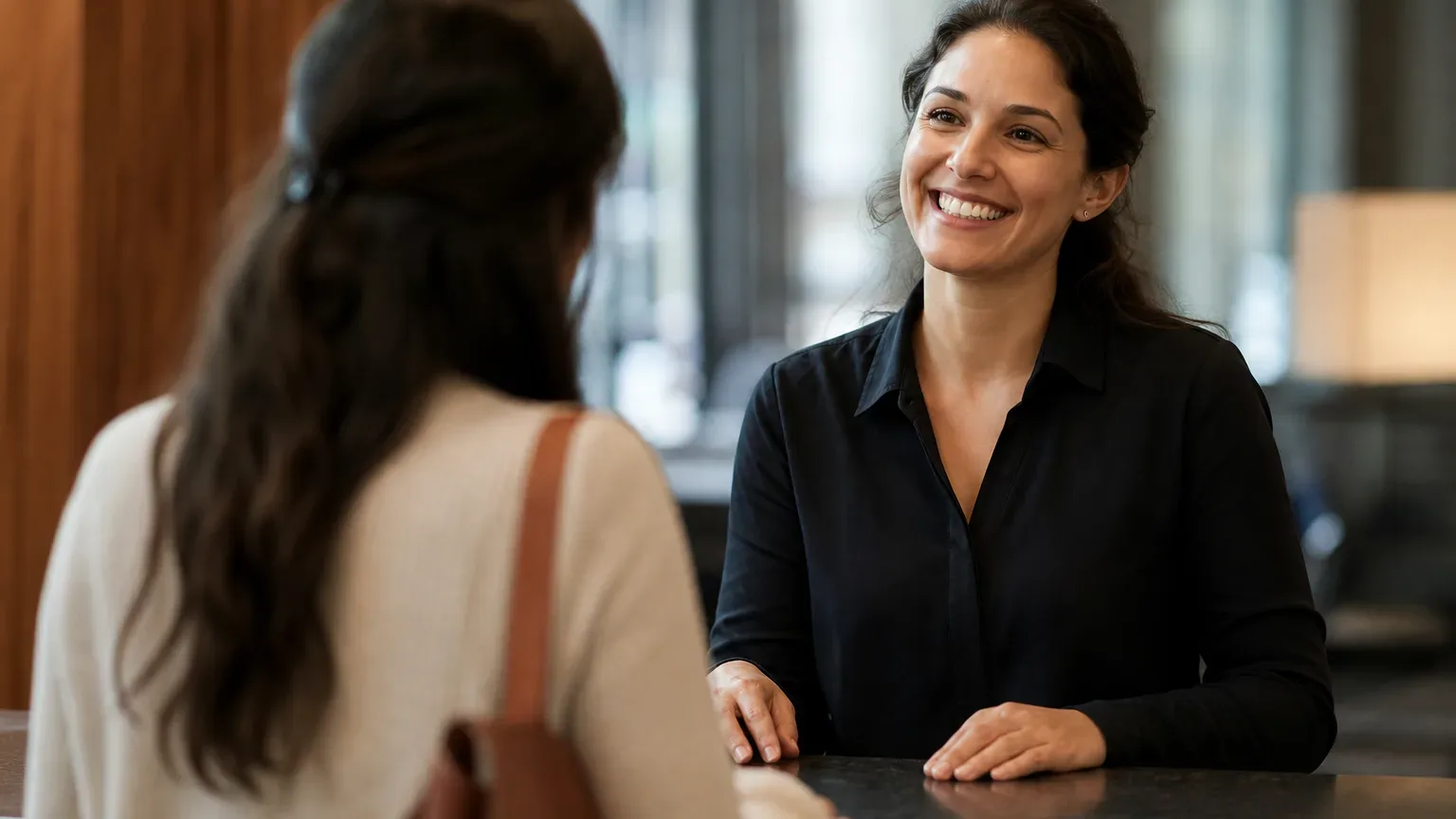 A first-time visitor being greeted by a smiling staff member at a check-in counter